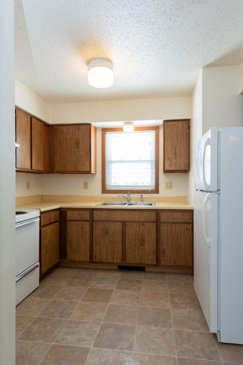 a kitchen with white appliances and wooden cabinets